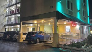 Un hotel llamado "Sea Palace Inn" con un estacionamiento visible y un letrero que indica disponibilidad.