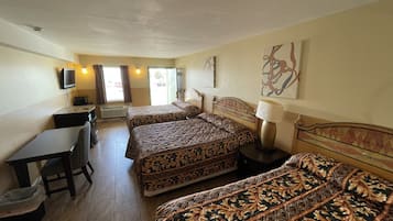 Habitación de hotel con dos camas, un escritorio, una silla, un televisor y una ventana con cortinas.