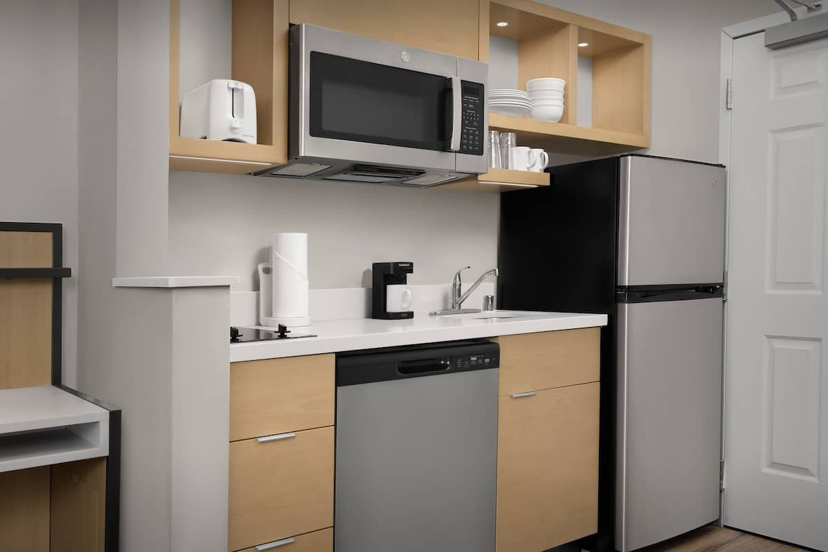 Una cocina moderna equipada con lavavajillas, microondas y refrigerador.