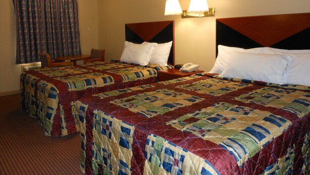 A hotel room with two beds, a desk, a chair, and a telephone. - McClellan Inn Anniston (Anniston)