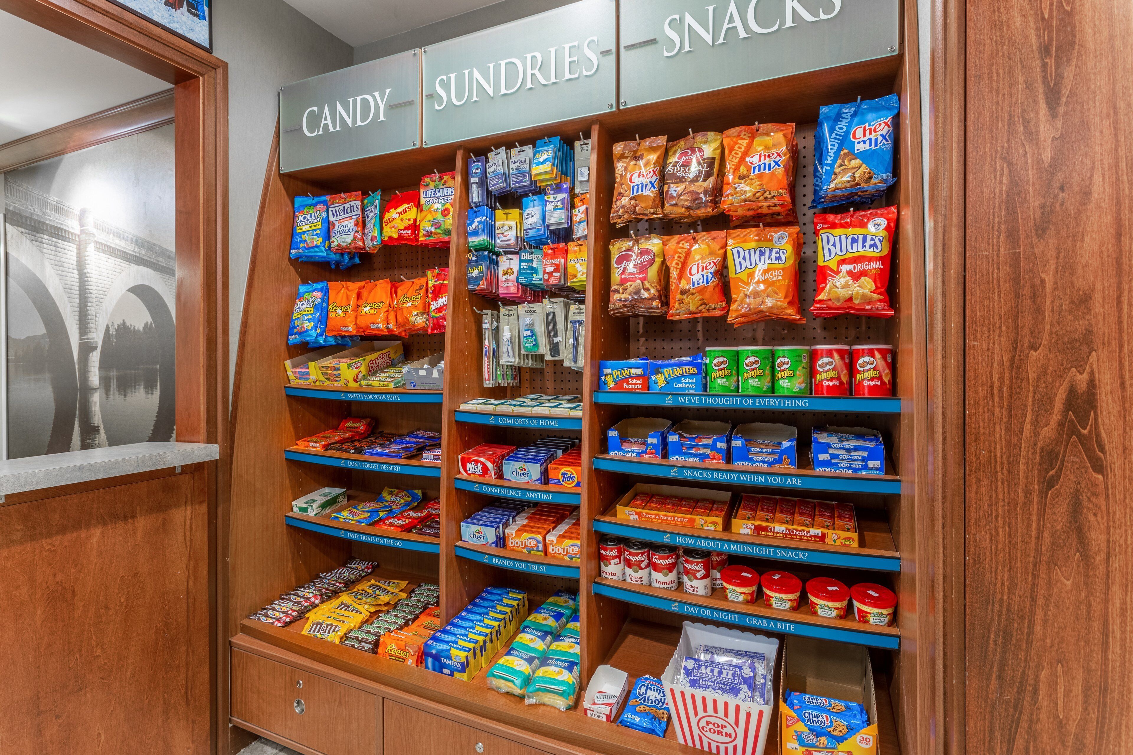 Een gedeelte met snoep en kleine artikelen, met diverse snacks en lekkernijen in de schappen.