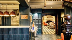 A hotel lobby with a reception desk, directional signs, a fireplace, and seating areas. - Cromwell Hotel Stevenage (Stevenage)