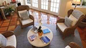 A cozy living area with wicker chairs, a round coffee table, and a potted orchid. - Jupiter Waterfront Inn (Jupiter)