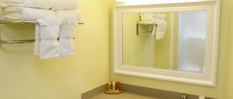 A bathroom with a sink, mirror, and towel rack.