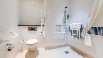 Un bagno moderno con il water, una doccia con soffione manuale, un appendi asciugamani e un piccolo ripiano con articoli da toilette.