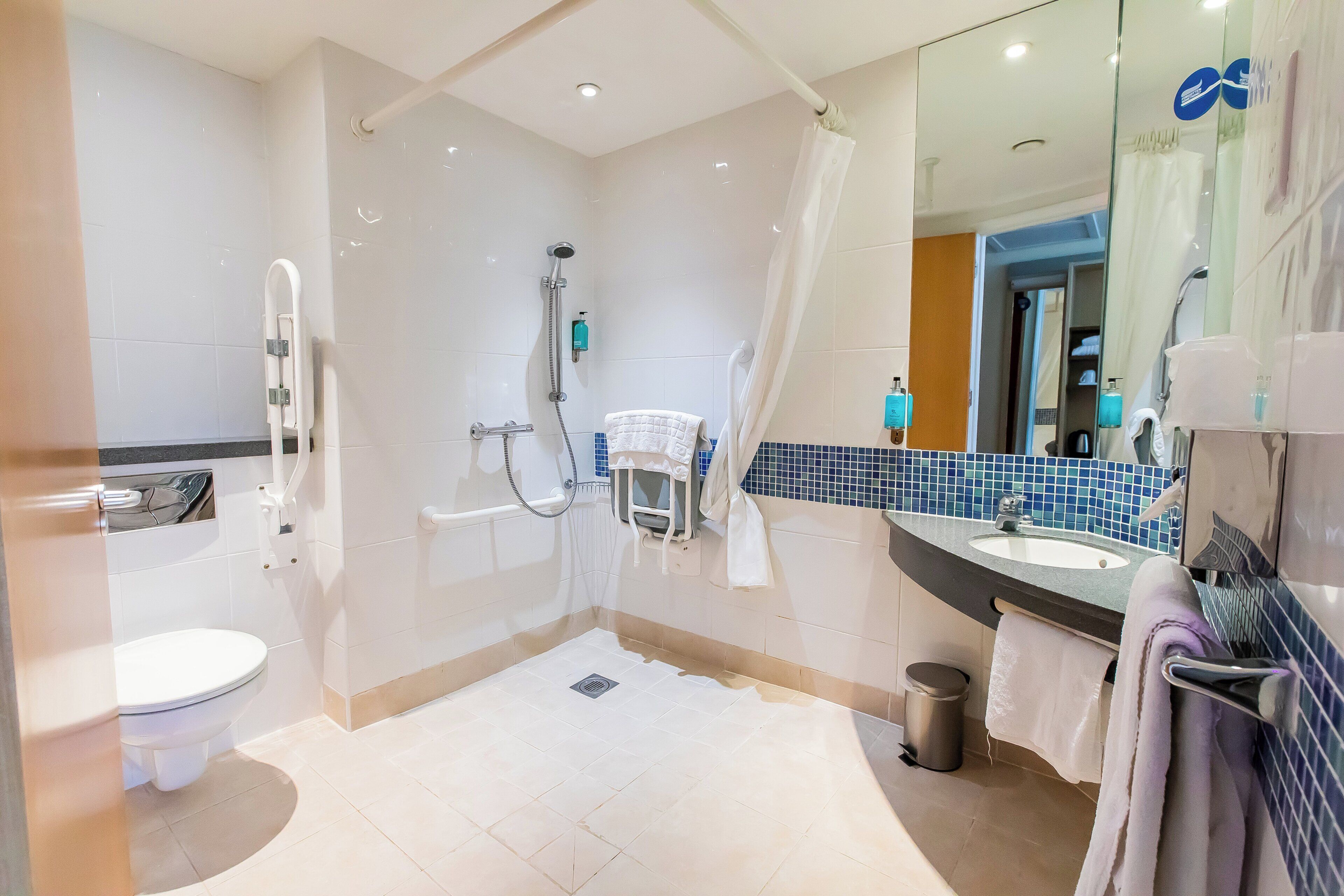A modern bathroom with a shower, toilet, and sink.