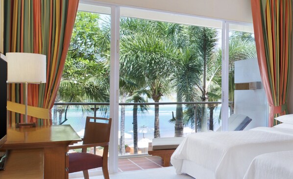 Una habitación de hotel con un ventanal grande, una cama, un escritorio y una silla.