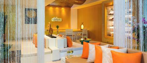 A modern hotel lobby with a reception desk, seating area, and a bar.