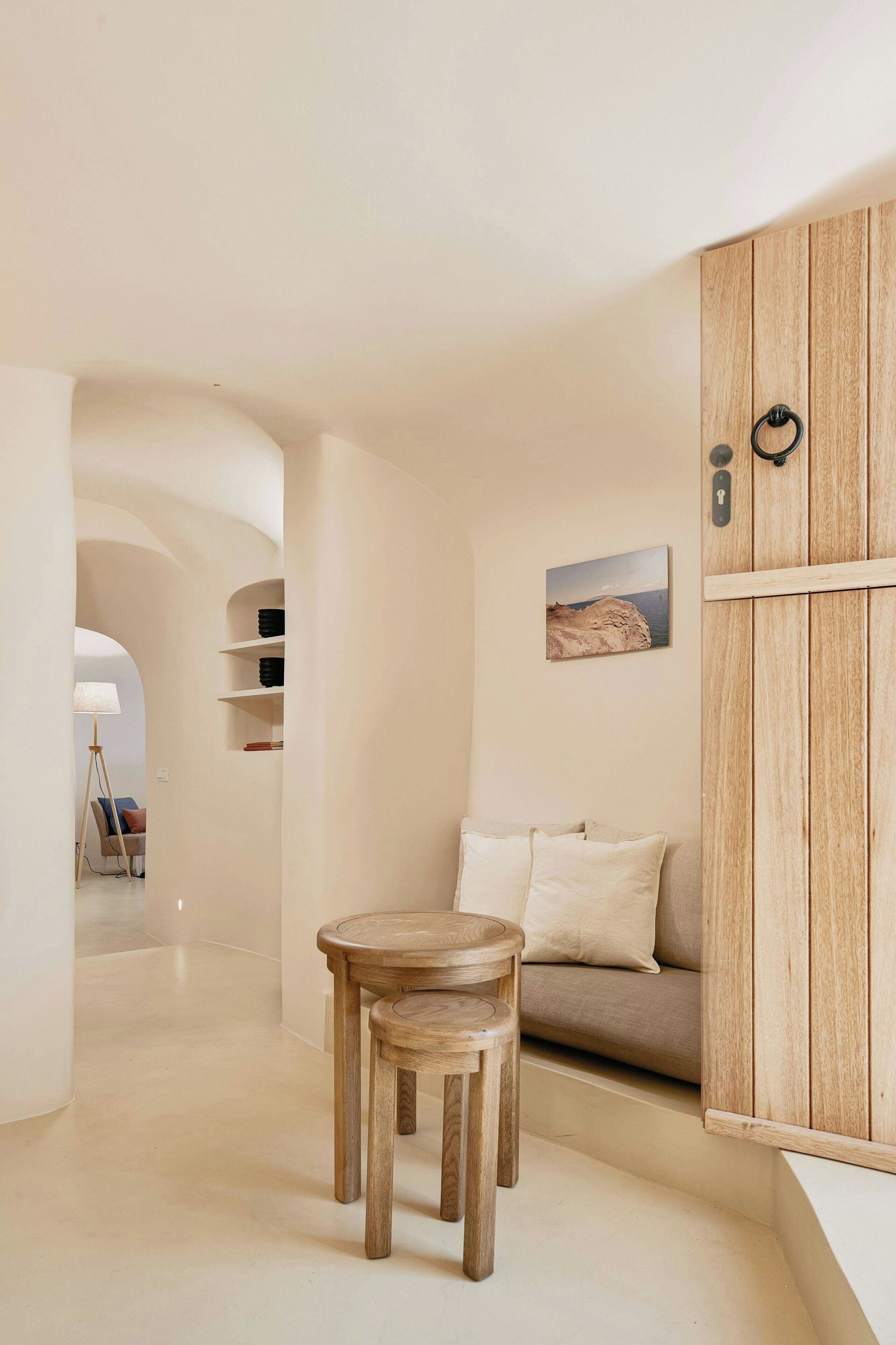 A minimalist living room with a wooden cabinet, a sofa, and a small wooden table.