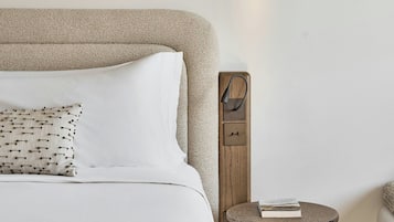A bedroom with a bed, a round side table, and a wall-mounted object.