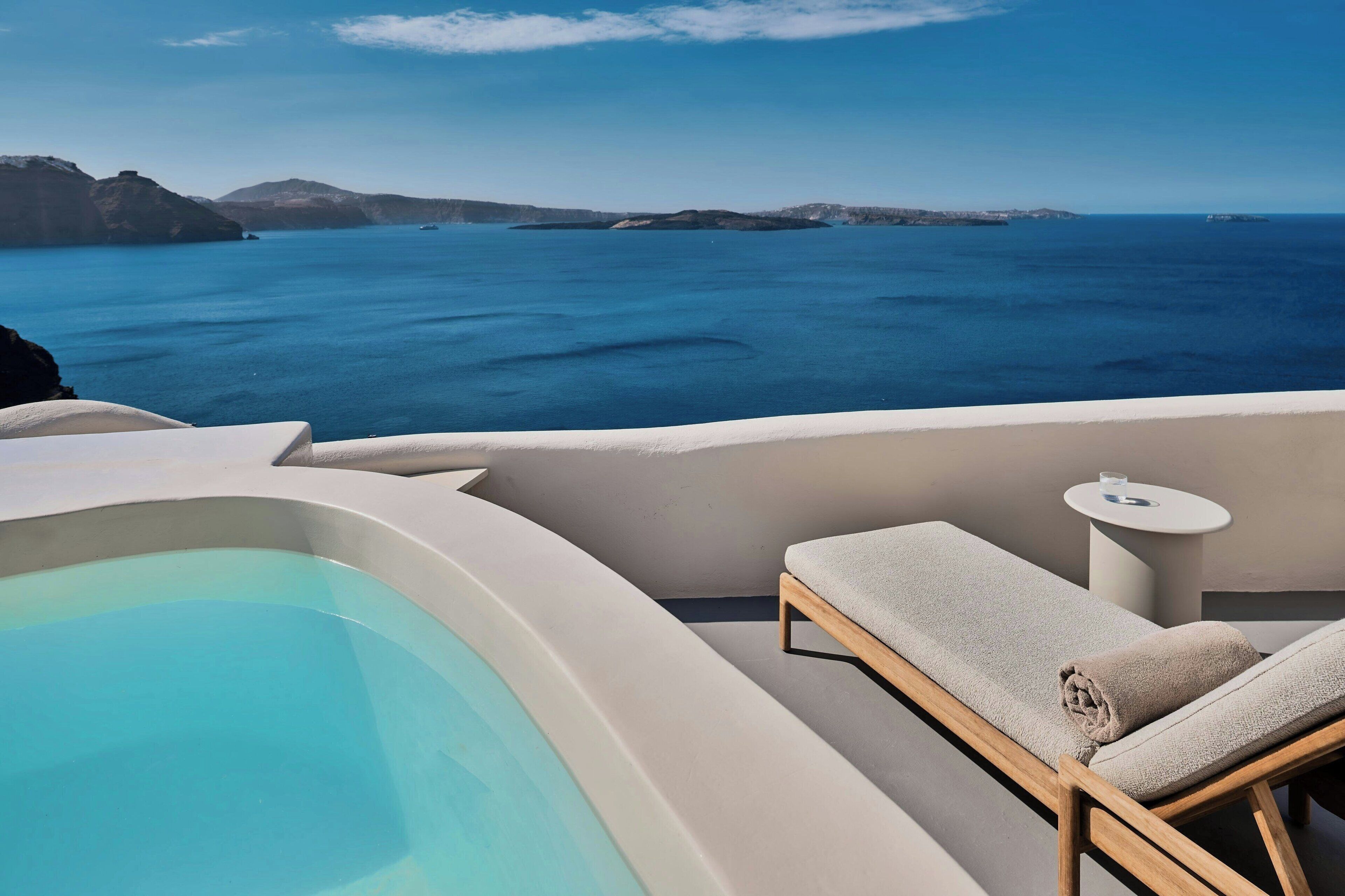 Un área junto a la piscina con vista al mar y a islas distantes.
