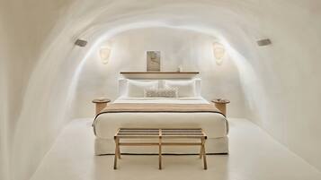 A minimalist bedroom with a bed, bedside tables, and a bench.
