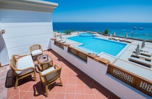A rooftop pool with a clear view of the sea, wicker furniture, and a tiled floor. - Reef Oasis Beach Aqua Park Resort  (Sharm El Sheikh)