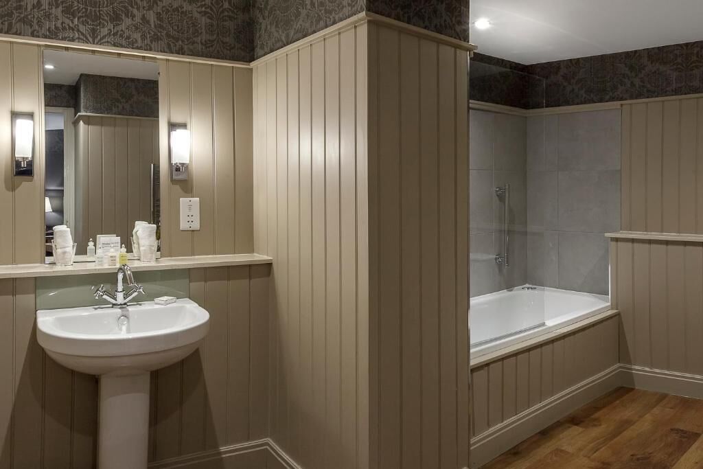 Une salle de bain avec un lavabo, un miroir et une baignoire.