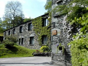 A stone building with a sign indicating it is a hotel. - The Langdale Hotel & Spa (Ambleside)