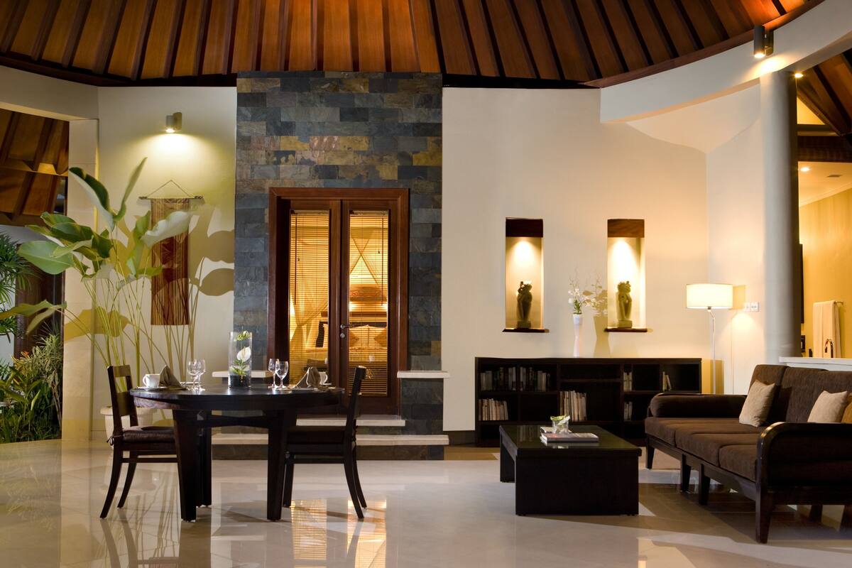 A spacious living area with a dining table, sofas, and a fireplace.
