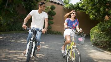 Two people riding bicycles on a paved path.