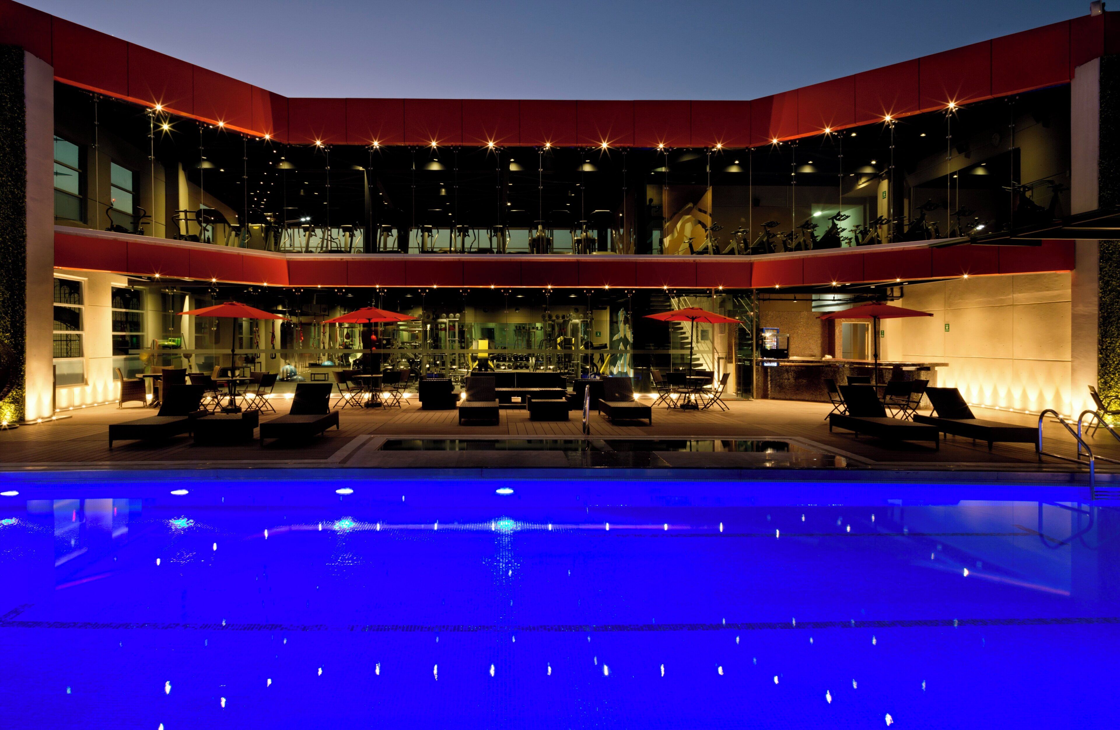 A multi-level outdoor pool area with seating and exercise equipment.