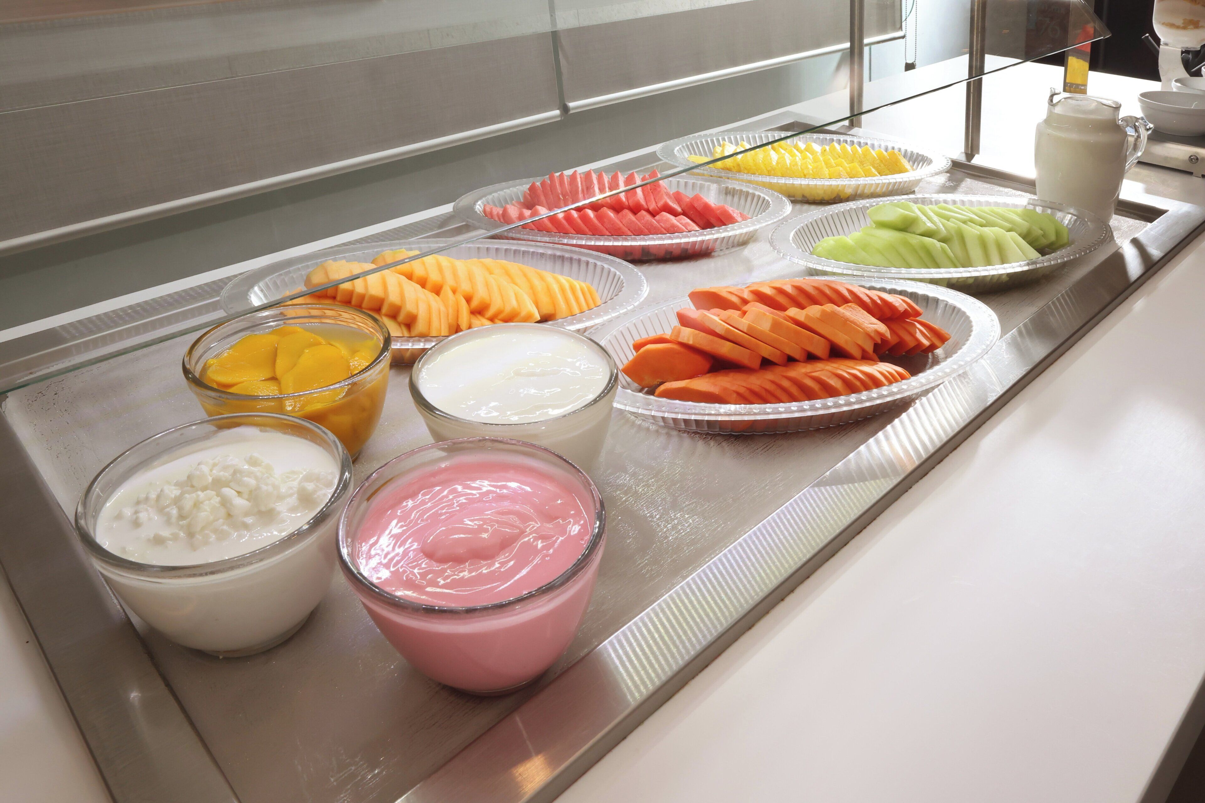 Een buffet met diverse soorten fruit en zuivere melkproducten.