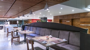 Enjoy a meal at a beautifully set dining area with a long bench and individual tables.