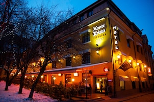 Un hotel con un letrero que dice "Mont Krista Vienna" y "HOTEL" en la fachada.