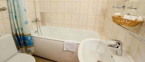 Un baño con bañera, inodoro y lavamanos.