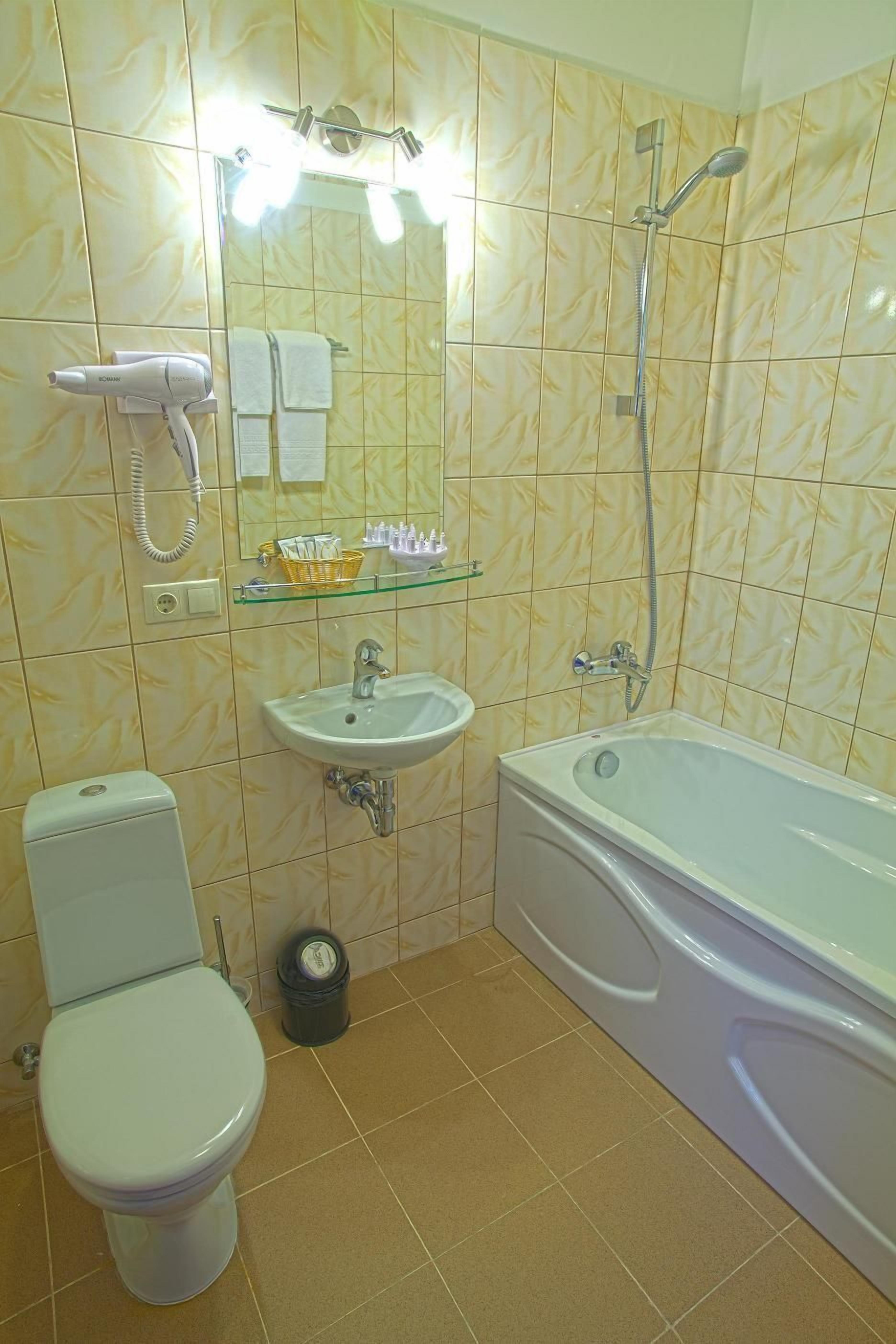 Een badkamer met toilet, wastafel en bad.
