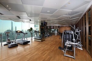 A modern gym with treadmills, elliptical machines, and weight equipment.