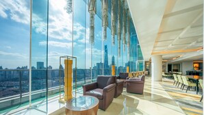 A spacious lobby with large windows offering a city view, modern furniture, and hanging crystal chandeliers. - The Eton Hotel (Shanghai)