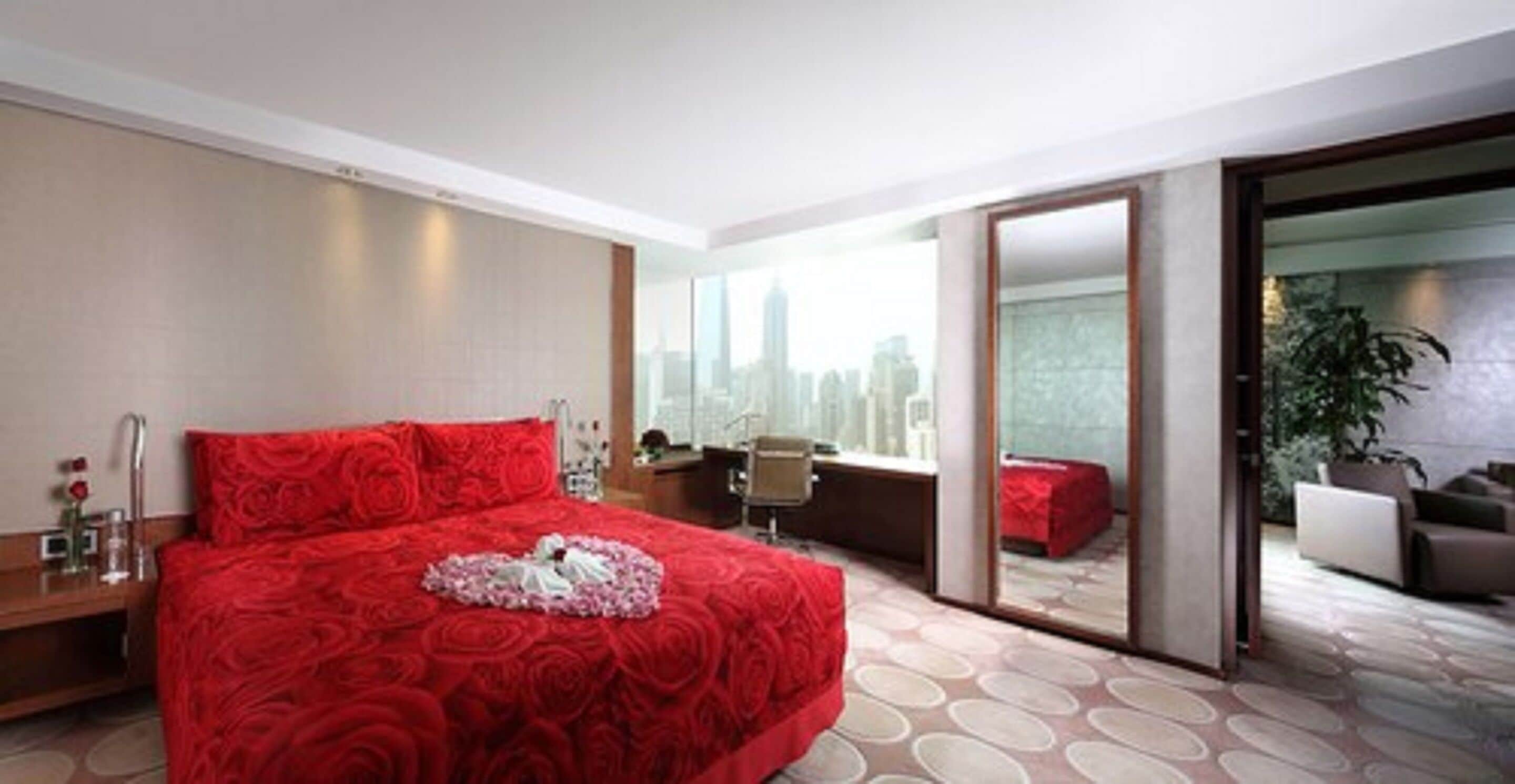 Une chambre d’hôtel moderne, dotée d’un grand lit, d’un bureau et offrant une vue sur la ville.
