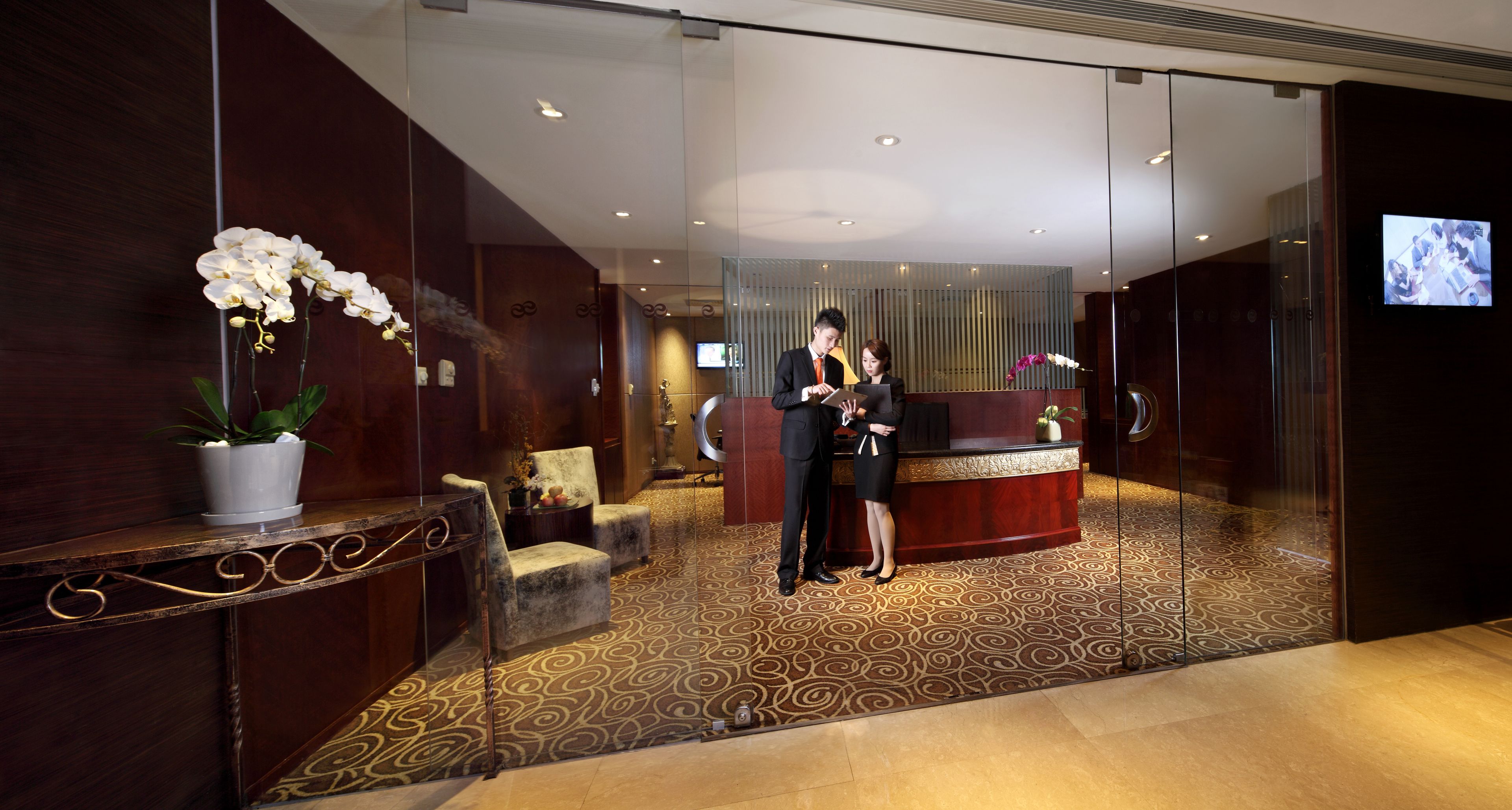 A reception area with a reception desk, a potted plant, and a seating area with chairs.