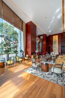 A spacious lobby with a large seating area, a reception desk, and a view of the outdoors.