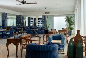 A spacious living area with a large mirror, wooden furniture, and a ceiling fan.