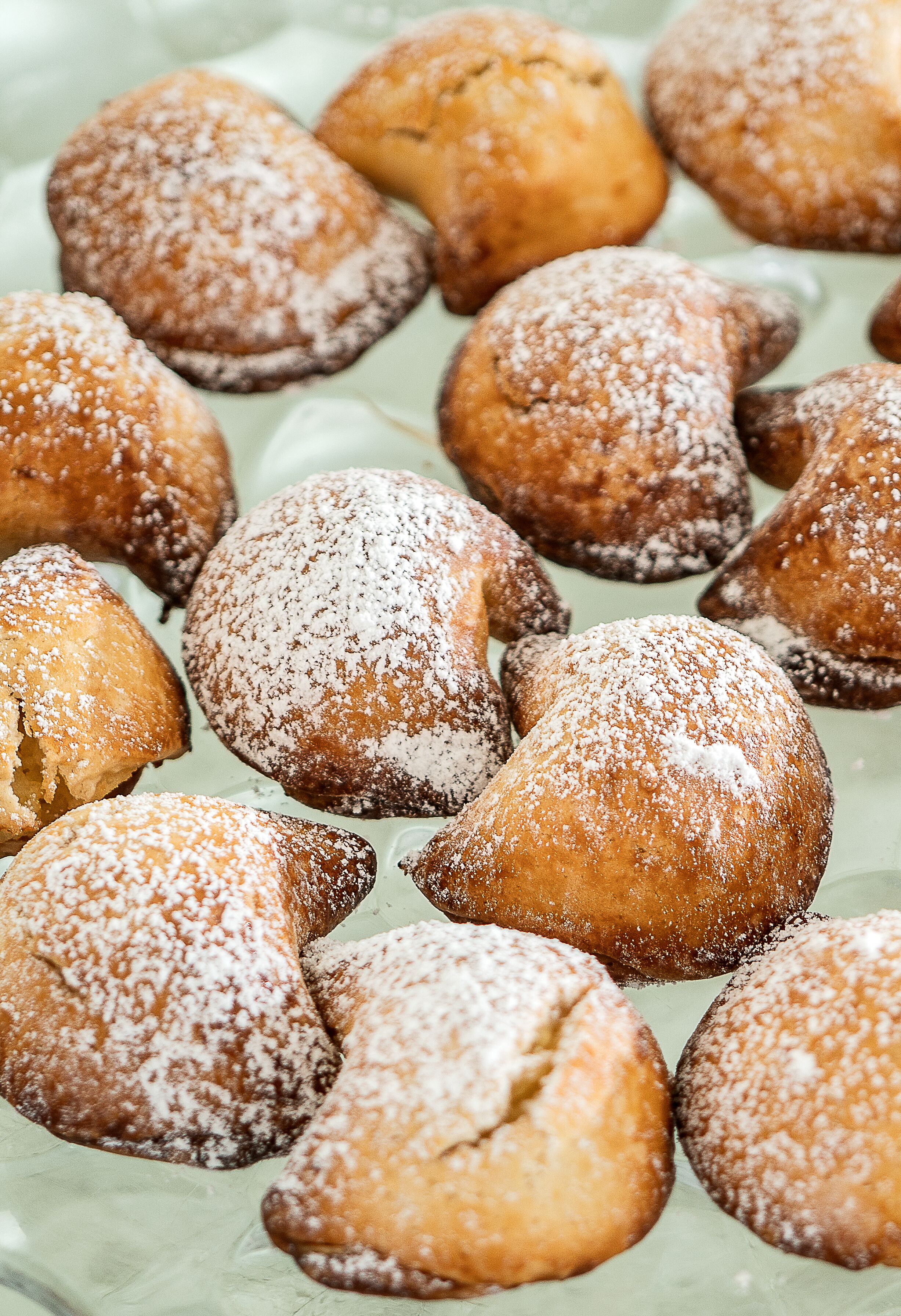 A variety of pastries dusted with powdered sugar.