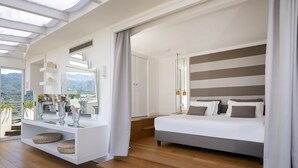 Un dormitorio moderno con una cama grande, un tocador con espejo y vistas al exterior.