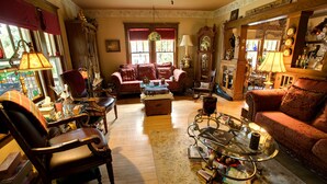 Uma sala de estar acolhedora com lareira, assentos confortáveis e uma mesa de centro com livros e objetos decorativos.