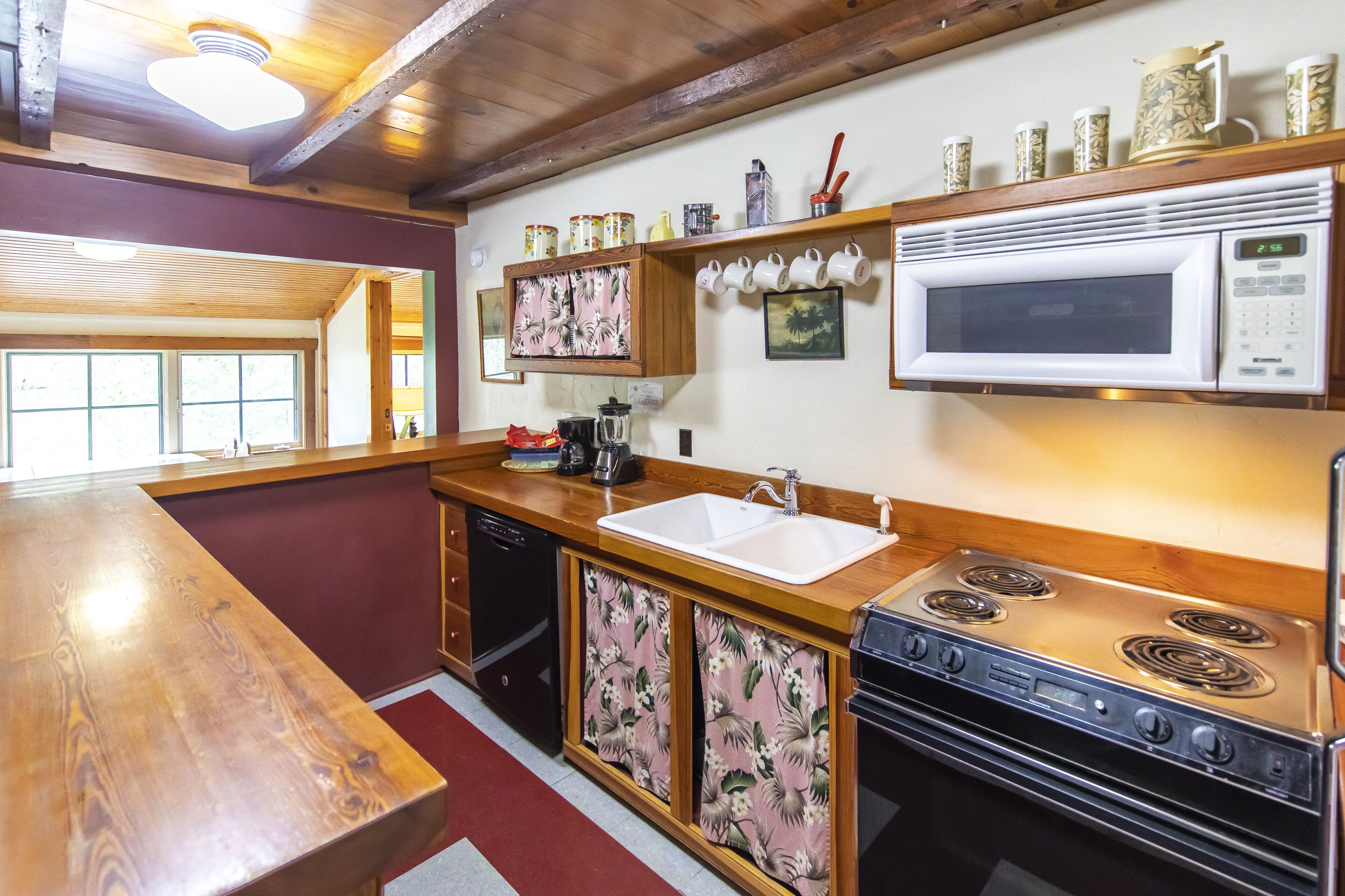 A kitchen with wooden cabinets, a stainless steel stove, a microwave, and a sink.