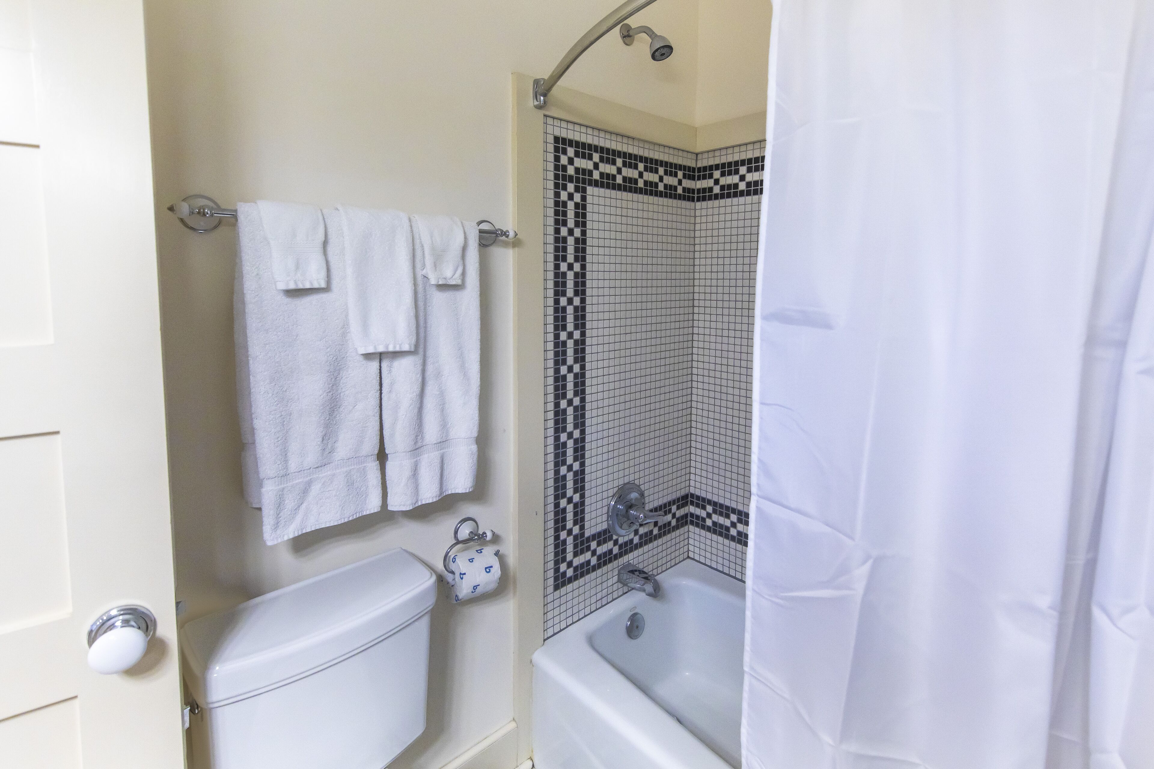 Un baño con inodoro, bañera y cortina de ducha.