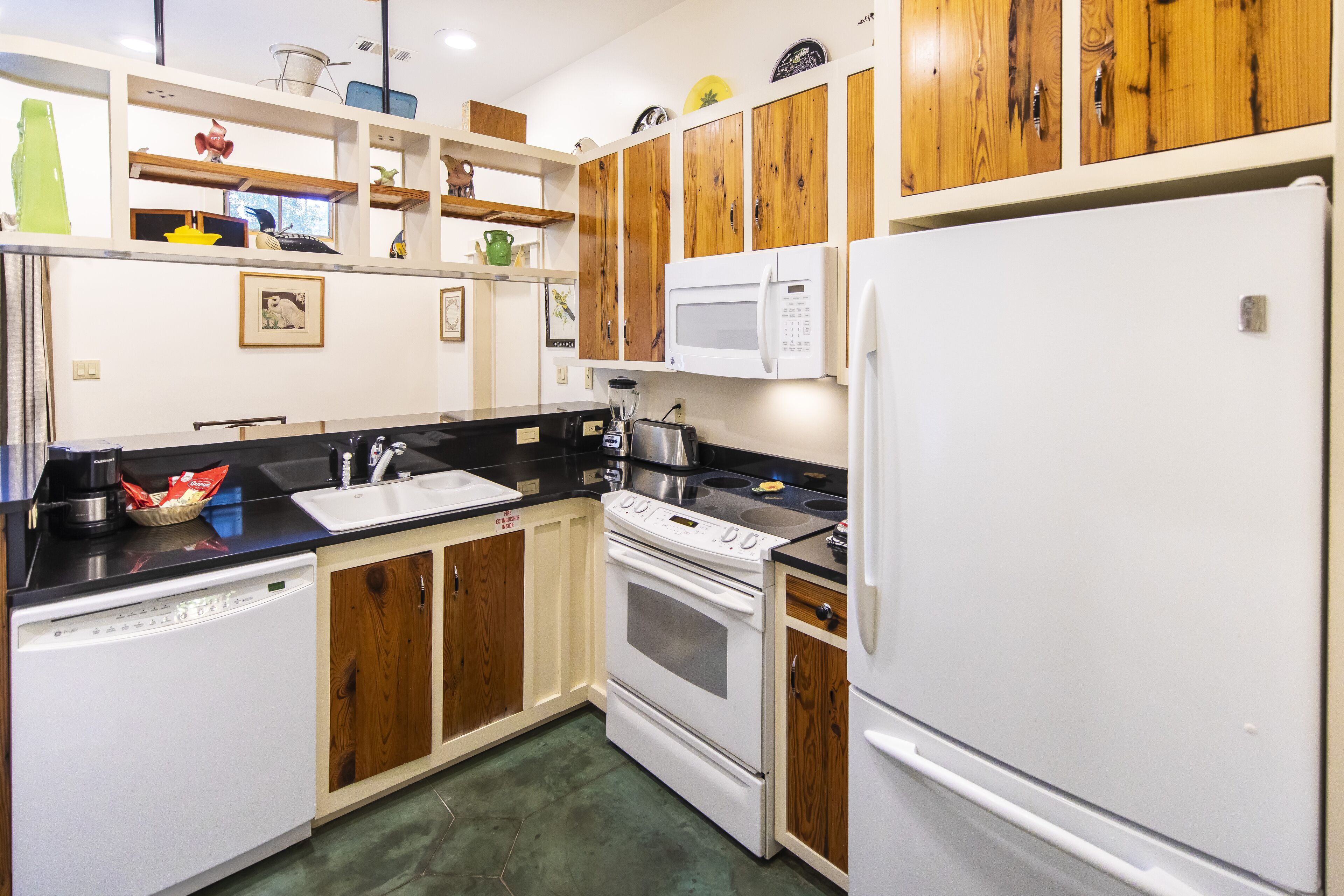 A kitchen with wooden cabinets, a white refrigerator, a microwave, a stove, and a dishwasher.