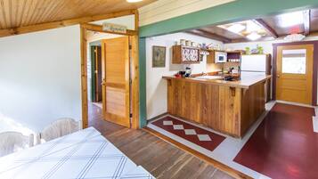 Una cocina compacta con armarios de madera, un microondas y un refrigerador.