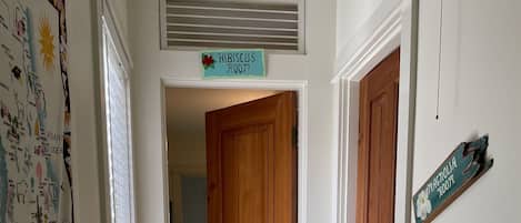 A hallway with a wooden door, a sign reading "Magnolia Room," and a wall with a map.