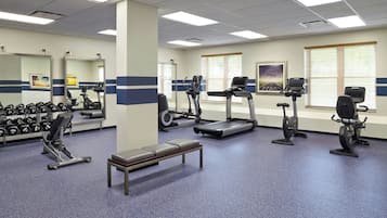 A gym with treadmills, elliptical machines, and free weights.