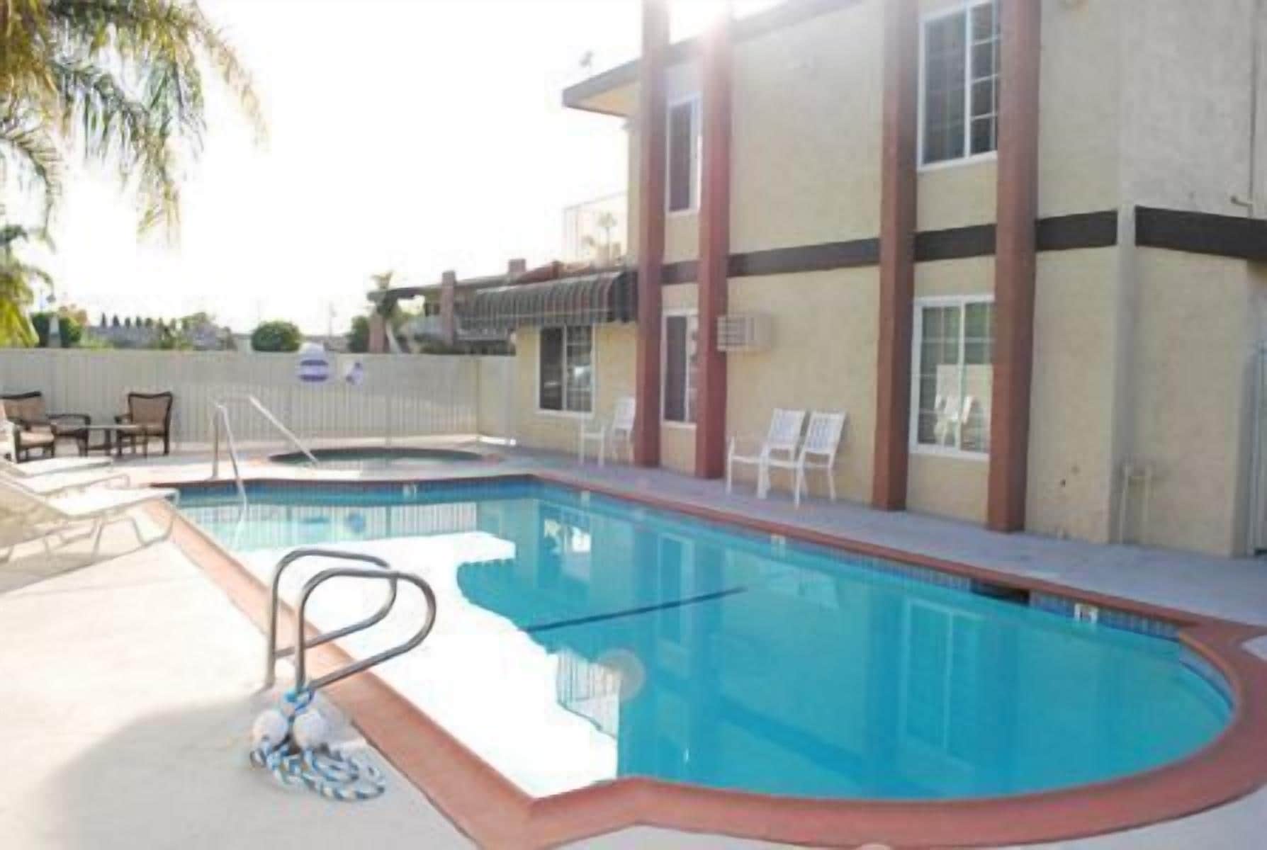 A swimming pool with lounge chairs and a poolside area.
