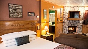 Een hotelkamer met een bed, een bank, een stenen openhaard en een muur met een bord waarop verschillende locaties staan vermeld.