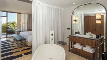Une salle de bain moderne avec une baignoire, un meuble-lavabo avec un miroir et un espace douche.