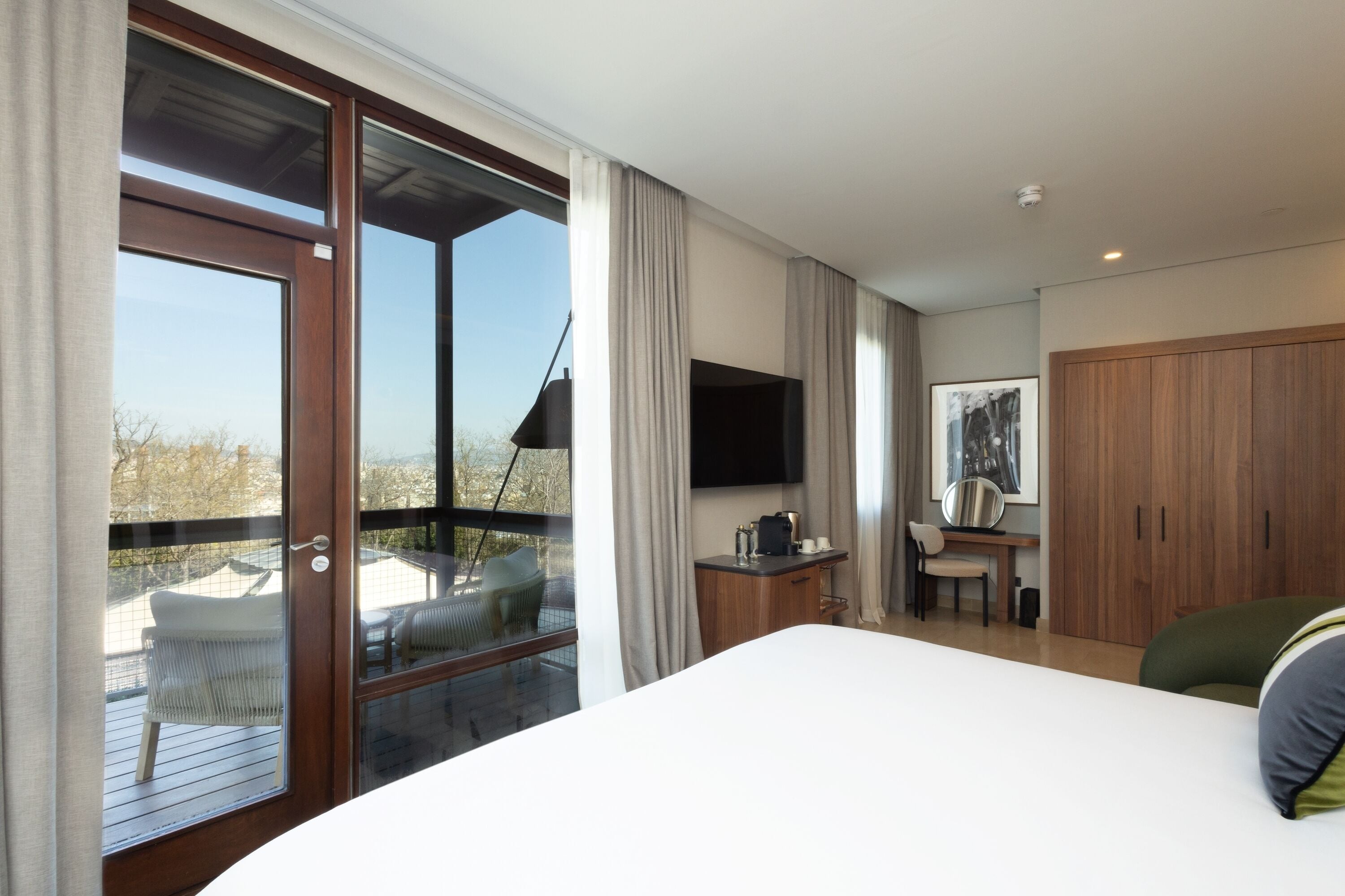 Une chambre avec un grand lit, un bureau avec une chaise, une télévision et une armoire.