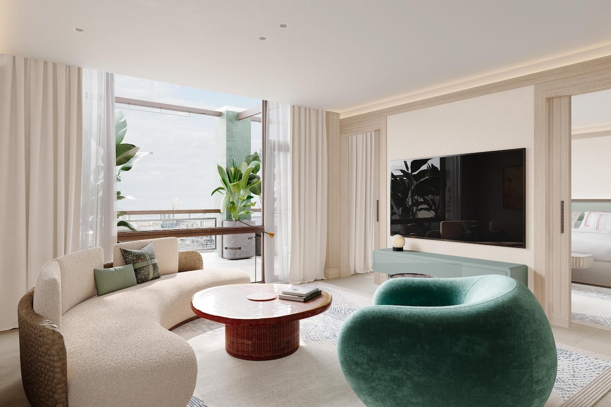 Ein modernes Wohnzimmer mit Sofa, Sessel und rundem Couchtisch.