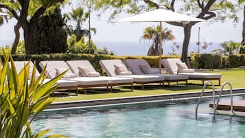 Een binnenzwembad, een buitenzwembad, ligstoelen bij het zwembad