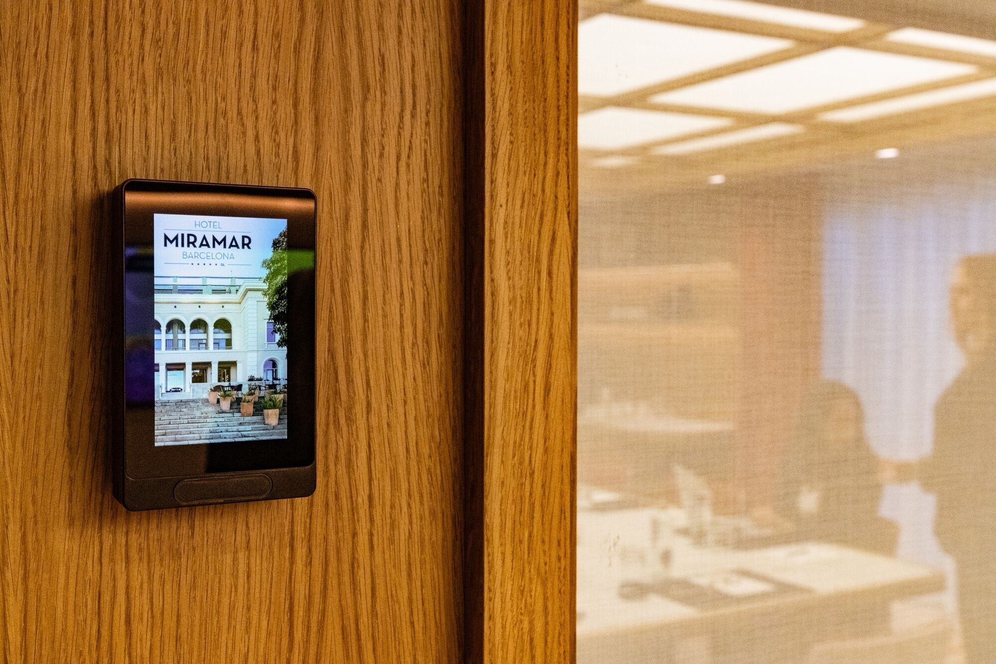 Un letrero digital en una puerta de madera que anuncia el HOTEL MIRAMAR en Barcelona.