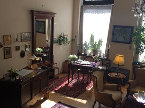 A cozy living room with a dining area, a large mirror, and various decorative items. - Aparthotel Rothensteiner (Vienna)